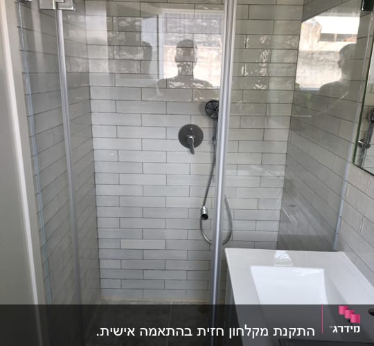 מקלחון זכוכית עם ראש מקלחת עגול וקירות אריחים
